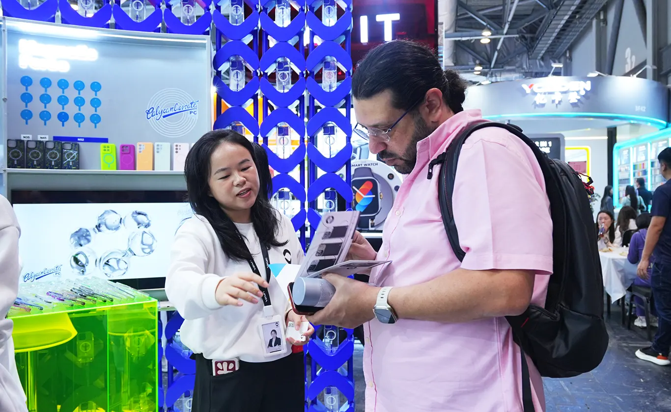Mobile phone case manufacturers explaining product features and showcasing sample cases to a buyer at the Hong Kong Global Sources Electronics Show
